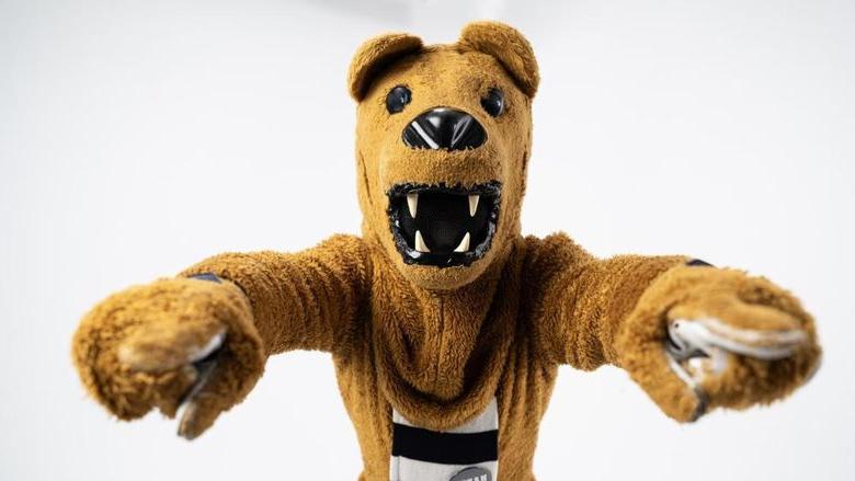 The Nittany Lion mascot points to the camera with both hands